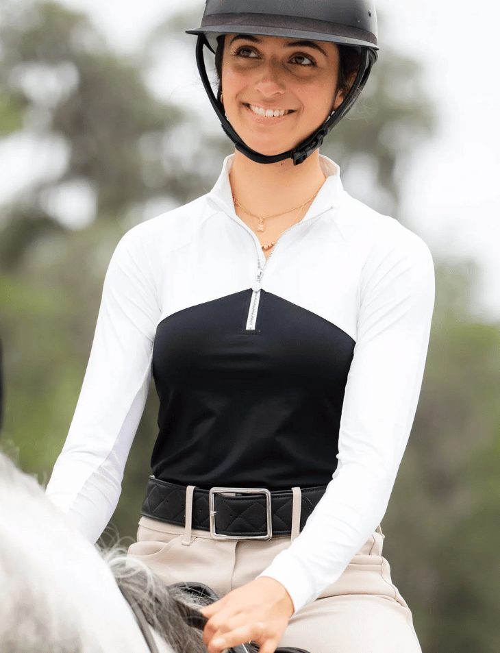 A smiling rider in a black and white Dapplebay Shine On show top and helmet