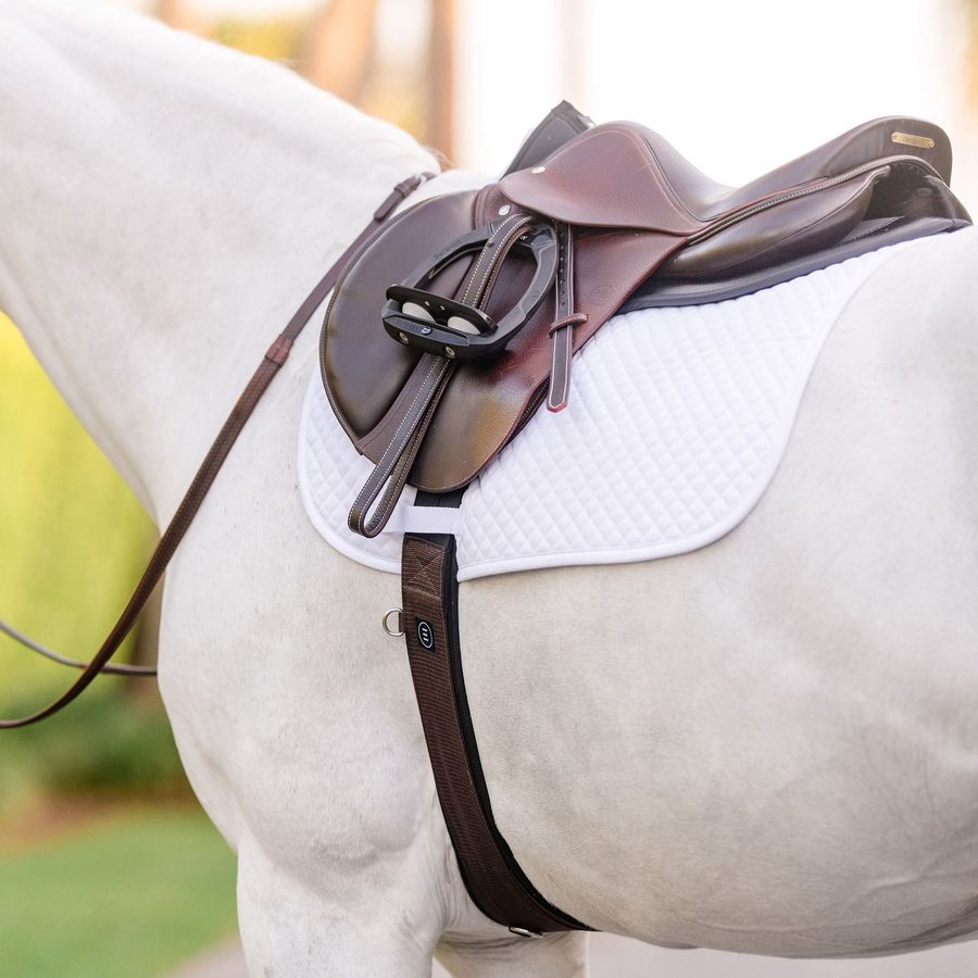 A grey horse in a brown EquiFit Essential Schooling Girth under a white saddle pad