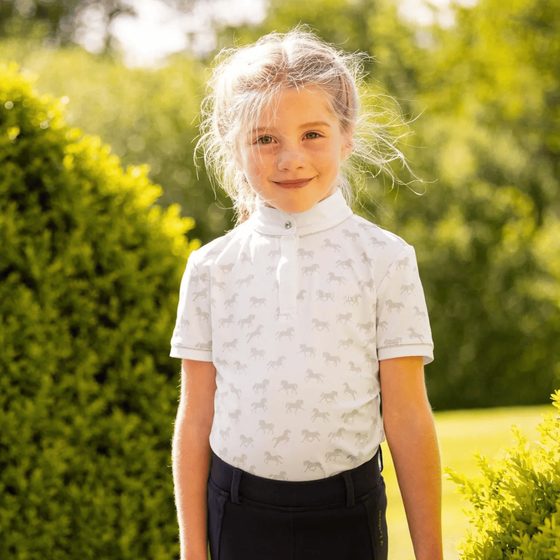 A smiling young rider in a white LeMieux show shirt