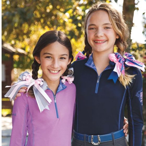 Two young riders in Romfh sun shirts and breeches